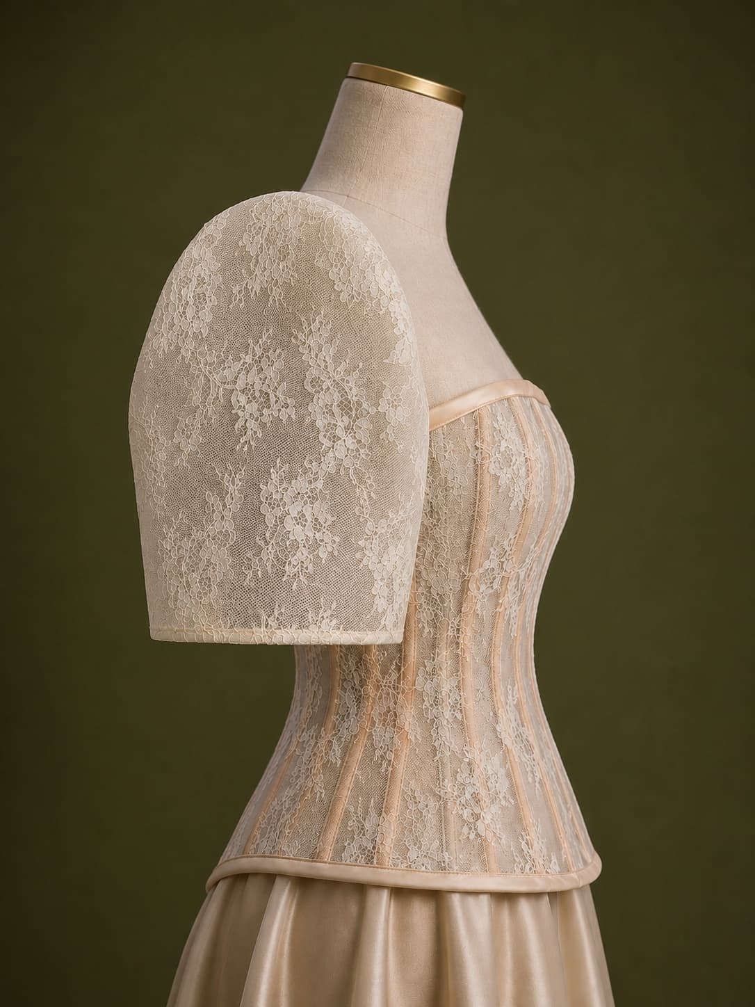 A lace bodice and detachable sleeve from the Arquila collection on a dress form